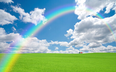 Obraz na płótnie Canvas 草原の赤い屋根の家と雲と虹