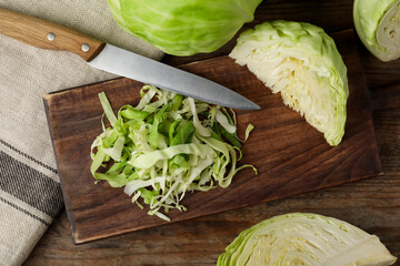 Chopped ripe cabbage on wooden table, flat lay