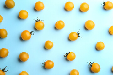 Yellow tomatoes on light blue background, flat lay