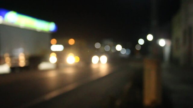Blurred image of a road at night with cars passing by