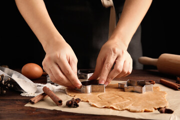 Woman making Christmas cookies at wooden table, closeup