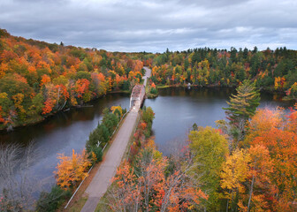 Fototapeta na wymiar Aerial view of McClure storage basin with old 510 bridge surrounded by fall foliage