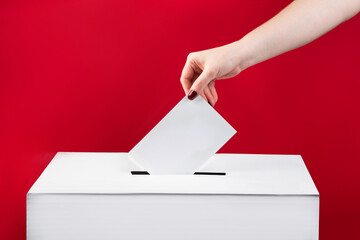 Woman puts a ballot paper in voting box on red background. Elections in the United States.