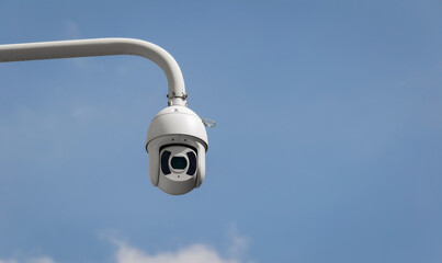 CCTV security cameras on a large post, taken on a sunny bright day with white clouds in the sky