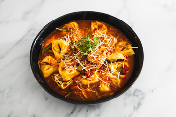 plant-based food, vegan eggplant tortellini with tomato sauce and dairy-free parmesan