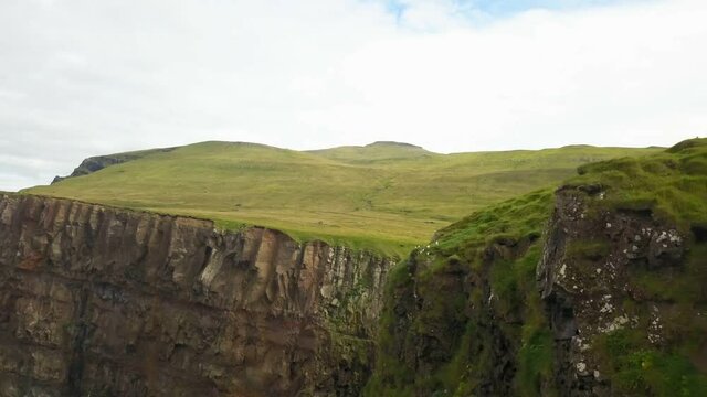 Green cliffs of farroe islands in cloudy weather. Drone aerial view.