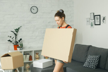 Caucasian woman at home opening carton box, just delivered parcel on address