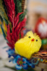 Traditional Polish Easter chick decoration with pisanki eggs in the background
