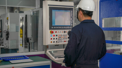 factory foreman in operation of cnc machine in factory control room