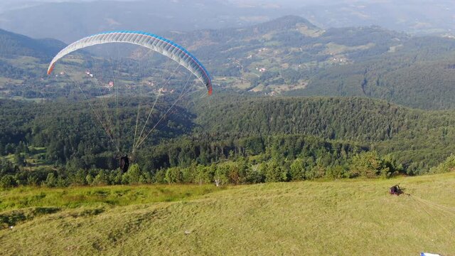 Paraglider Starts Flight From Hill Above Green Mountain Landscape of Zlatbor, Serbia. Drone Aerial View