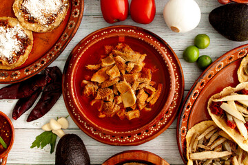 Platillo tipico mexicano. Pancita cocinada en caldo rojo de chile ancho en composicion cenital...