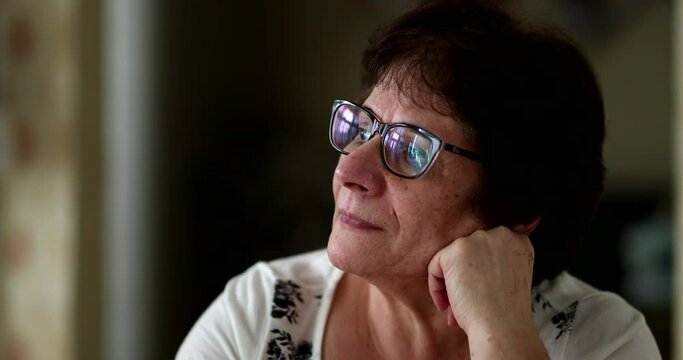 Portrait 60 year old woman daydreaming and looking at camera