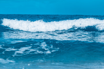 Water wave splash on blue sea background.