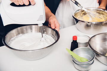 Woman cooking whisk dough mixer in bowl by machine at homemade