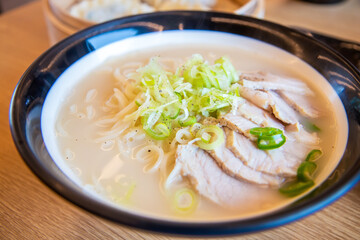 Close up image of Korean traditional food, soy milk noodle soup, Kong GukSu, with sliced meat and onion