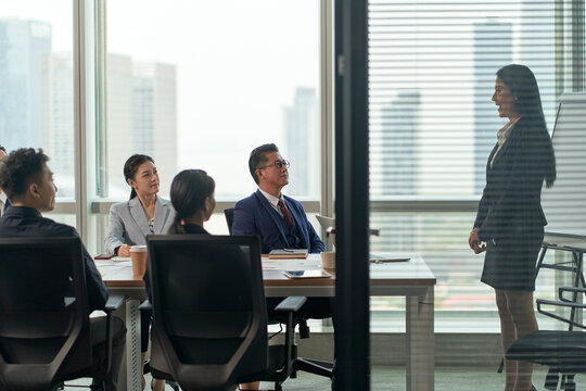 team of asian corporate executives discussing business in conference room