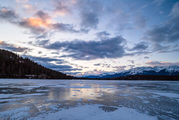 Mountains and trees seen from a frozen Pyramid Lake. Jasper, Alberta / Canada.