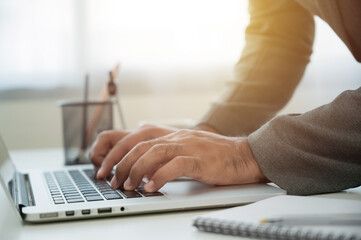 Close up Businessman hands working in office with laptop. Businessman typing the keyboard and planning the project.