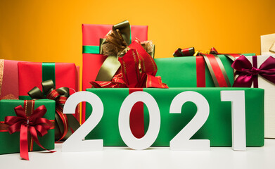 Fototapeta premium 2021 years. A lot of gift box mockup wrapped decorated with ribbon bow. Big pile of gift set stack on yellow background color. Merry christmas and Happy new year festival concept.