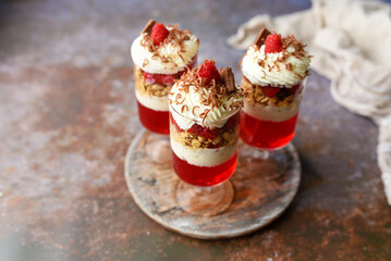 Dessert in a glass, raspberry jello with granola on yogurt and whipped topping   