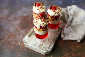 Dessert in a glass, raspberry jello with granola on yogurt and whipped topping   
