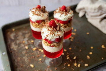 Dessert in a glass, raspberry jello with granola on yogurt and whipped topping   