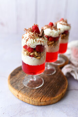 Dessert in a glass, raspberry jello with granola on yogurt and whipped topping   