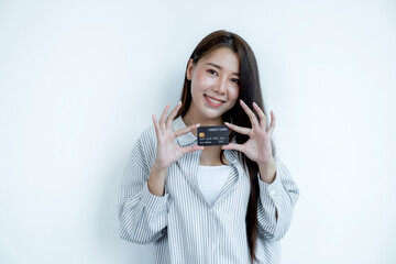 Portrait of a lovely young Asian beautiful woman with long hair holding a black credit card, her eyes sparklingly at the camera. Ready to pay shopping according to discounted products