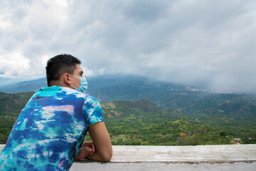 Fototapeta premium Hombre con mascarilla mirando hacia el horizonte. Vida después de cuarentena