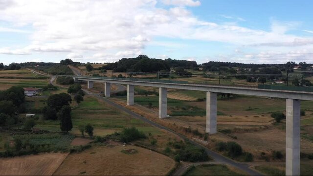 Drone Shot Of A Railway Bridge By The Lush Field In Botos, Spain - aerial landscape