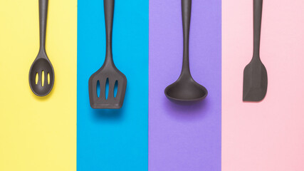 Four silicone kitchen accessories neatly stacked on a multi-colored background.