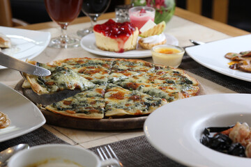 Delicious hot pizza with fresh spinach, garlic and cheese close-up on a board on a table. horizontal