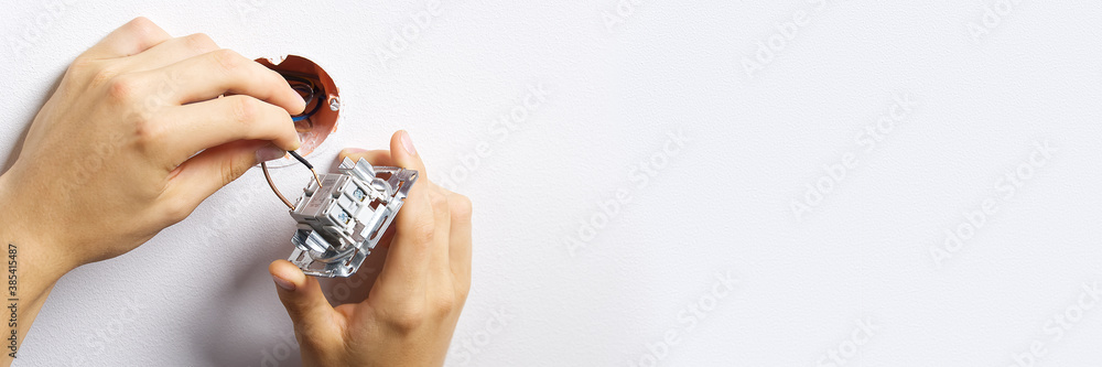 Poster electrician installing light switch on painted wall with screwdriver. man installing light switch af