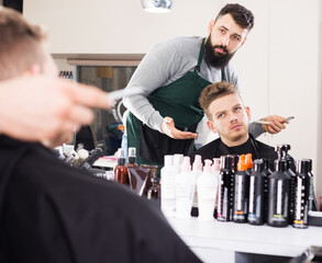 Client looking displeased about his new haircut at hair salon