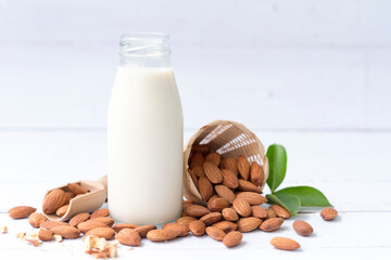 Homemade almond milk in a small bottle and almond in basket isolated on a white background, healthiest nuts and one of the best brain foods.Selective focus.