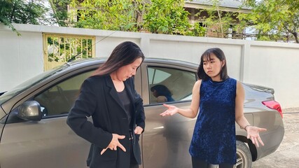 Fototapeta premium Woman and young standing find key in the pocket beside the car of holiday weekend vacation.