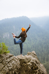 Mujer haciendo yoga en las alturas de una montaña