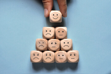 Image of different emotions on wooden cubes. Choice of positive emotions.