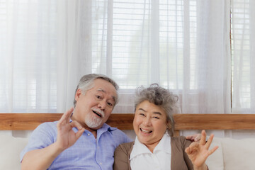 Asian happy retired senior smiling cute eldery couple enjoying & laughing together in home. Romantic relationship of lovely & beautiful marriage lover with happiness lifestyle after retirement.