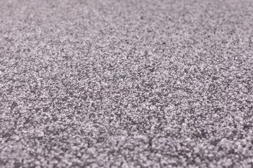 Think layer of hail on a surface of black trampoline