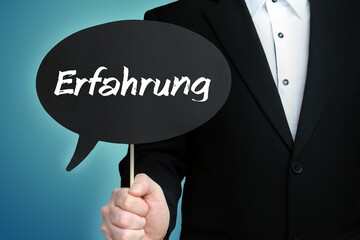 Erfahrung. Mann (Anwalt) hält Schild mit Beschriftung. Sprechblase mit Text (deutsch). Hintergrund blau