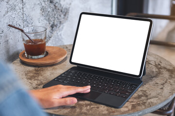 Mockup image of a woman touching on tablet touchpad with blank white desktop screen as a computer pc on the table