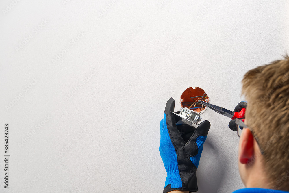Poster electrician installing light switch on painted wall with screwdriver. man installing light switch af