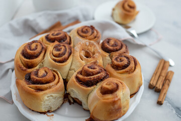 Cinnamon rolls with sugar frosting. With cinnamon sticks and spices, wooden background