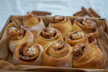 Cinnamon rolls with sugar frosting. With cinnamon sticks and spices, wooden background