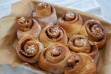 Cinnamon rolls with sugar frosting. With cinnamon sticks and spices, wooden background