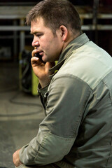 Close-up portrait of a man in the workplace with a mobile phone