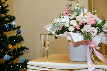Winter wedding bouquet of pink roses, pine cones and christmas tree branches on snow, copy space