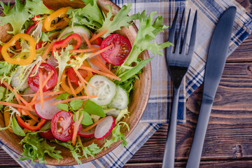 Fresh chopped vegetables on a plate on a wooden table.