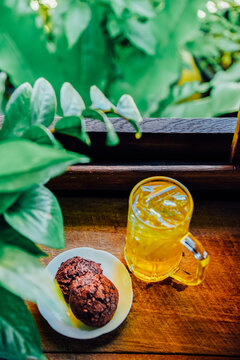 Chinese Chrysanthemum Tea in tall glass and  Brownie cookies on wood table, health herbal tea.
